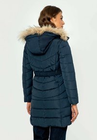 Námořnický puff coat s kapucí z umělé kožešiny, prošívaný vzor, elastický pas a dlouhé rukávy, poskytující neformální a teplou svrchní vrstvu.