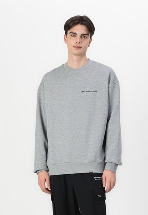 Gray sweatshirt with a crew neckline, dropped shoulders, and "don't waste culture" embroidered on the chest. Soft fabric and relaxed fit.