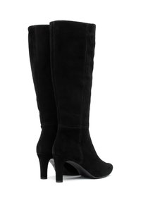 Botas de gamuza negra hasta la rodilla con un tacón afilado, textura suave y costuras verticales, que presentan una puntera redonda y un tubo ajustado.