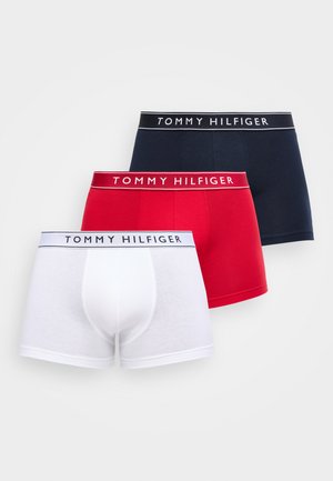 Tre sammenfoldede Tommy Hilfiger bokserbriefs i hvid, rød og marineblå med mærkede linninger, arrangeret overlappende på en hvid baggrund.