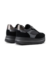 Un paio di sneakers platform nere con accenti grigi e metallici argentati, suole spesse e design con lacci, mostrato da dietro e di lato.