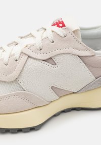 Sneaker mit einer Mischung aus Texturen in Weiß und Hellbeige, runden Schnürsenkeln, einem erhabenen N-Logo und einer gepolsterten Sohle mit schwarzer Laufsohle.