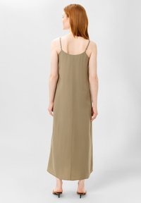 Vestido maxi sin mangas en color caqui con tirantes finos, textura suave y silueta recta. Presenta un dobladillo redondeado y costuras mínimas.