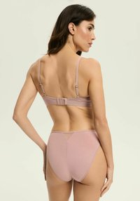 Jasnoróżowy zestaw biustonosza i majtek z wysokim stanem, wykonany z gładkiego materiału, z regulowanymi ramiączkami, zapięciem na haftkę oraz przezroczystymi akcentami.