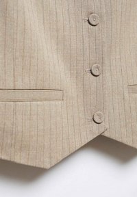 Gilet beige à fines rayures avec trois boutons recouverts de tissu et deux poches passepoilées horizontales, taillé avec un ourlet en forme de V.