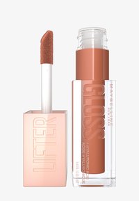 Maybelline Lifter Gloss w przezroczystym opakowaniu z różowym prostokątnym korkiem. Aplikaor ma miękką, puchatą końcówkę i jest wypełniony nagim odcieniem.