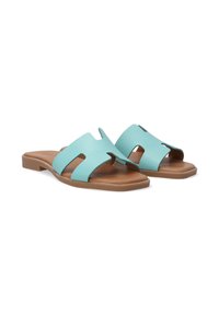 Aqua blue slide sandals with cut-out design, made of textured synthetic material, featuring a smooth brown footbed and low heel.