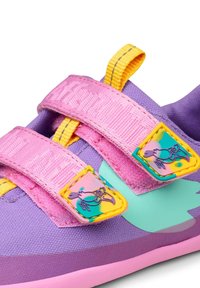 Lila Schuh mit pinken Klettverschlüssen und gelben Akzenten. Enthält bunte Aufnäher mit Vogelmotiven. Strukturierter Stoff und eine pinke Sohle.