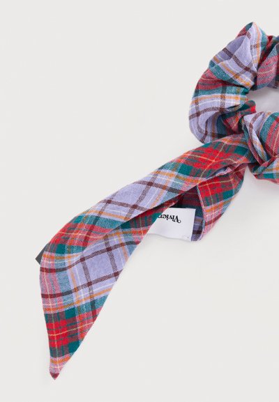 Scrunchie από καρό ύφασμα με δεμένο μαντίλι σε κόκκινους, πράσινους, μοβ και κίτρινους τόνους σε λευκό φόντο.