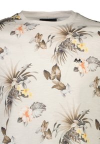 Lyhythihainen paita vaaleassa beigessä, jossa on värikäs trooppinen kukkapainatus, jossa on hibiskuksia, palmulehtiä sekä pehmeän harmaan ja keltaisen yksityiskohtia.