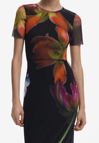 Robe à motifs floraux avec une silhouette ajustée, présentant des fleurs vibrantes orange et vert sur un fond noir, des manches courtes en voile et un nœud noir.