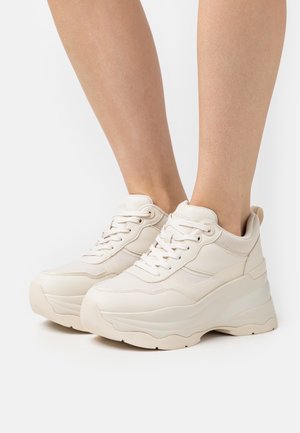 Sneakers platform beige con tessuto testurizzato e tomaia in similpelle liscia, design con lacci e suola spessa in gomma.