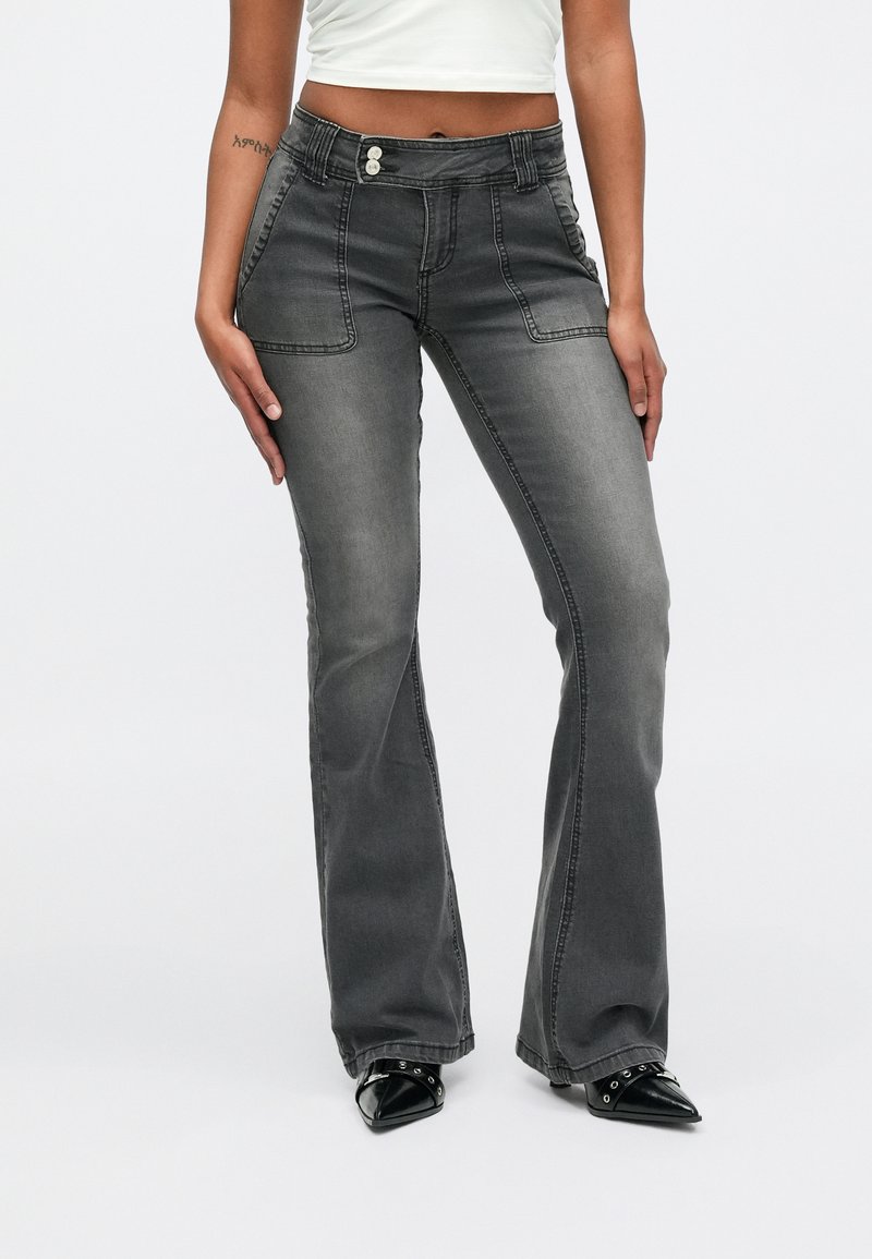 Hallid laiendatud teksad, millel on vormis vöökoht, ees taskud ja kaks nuppu. Tekstureeritud kangas omab tumedast helehallini ulatuvat gradienti.