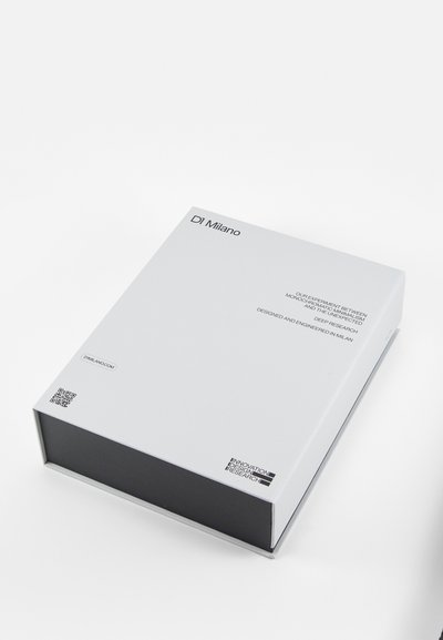 Witte rechthoekige doos met een matte afwerking, met een zwarte onderrand en geprinte tekst. Bevat een QR-code aan de zijkant.