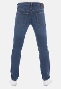 Pantalones vaqueros de mezclilla azul oscuro con un corte recto, que cuentan con bolsillos traseros con costuras curvas y una etiqueta de cuero marrón en la cinturilla.