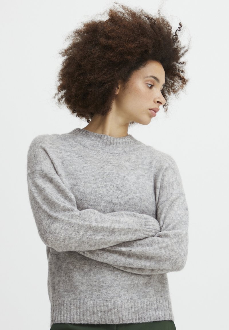 Grå strikket sweater med rund halsudskæring, ribbede manchetter og kant; blødt materiale og løs pasform med et subtilt mønster.