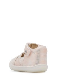 Růžová, texturovaná obuv s suchým zipem, kulatou špičkou, měkkým semišem a flexibilní bílou podrážkou.