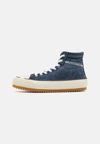 Sapatilhas de cano alto feitas de denim azul com atacadores brancos, bico de borracha creme e sola de borracha texturizada com bordas serrilhadas.