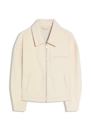 Jachetă de culoare crem, cu guler, închidere cu fermoar, două buzunare laterale și un buzunar la piept. Confecționată dintr-un material moale, cu o croială lejeră.