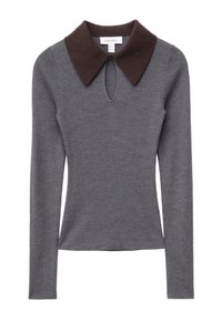 Graues, geripptes Langarmoberteil mit einem braunen, kontrastierenden Kragen und einem Schlüsselloch-Ausschnitt am Halsausschnitt. Glatte Textur und taillierter Schnitt.