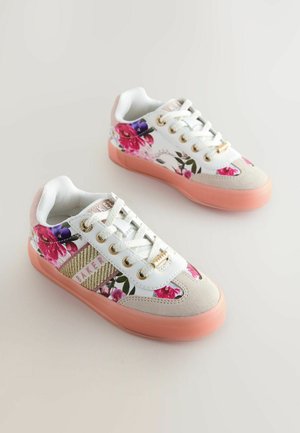 Weiße Sneakers mit Blumenmuster und einer pinken Gummisohle, ausgestattet mit goldfarbenen Metallteilen, Mesh-Struktur und gepolstertem Schaft. Blumenmuster in Pink und Lila.