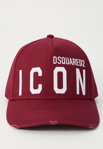 Casquette de baseball bordeaux avec une visière courbée. Présente un logo "DSQUARED2" en blanc et "ICON" en lettres majuscules. Fabriquée en tissu texturé, légère usure visible.