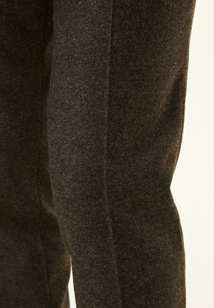 Mörkgrå tygbyxor med texturerad väv, med en smal passform och en strömlinjeformad silhuett, framhävd av en ren, rak söm.