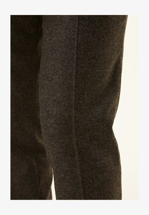 Pantaloni in tessuto grigio scuro con una trama texturizzata, caratterizzati da una vestibilità slim e una silhouette snella, evidenziati da una cucitura pulita e dritta.