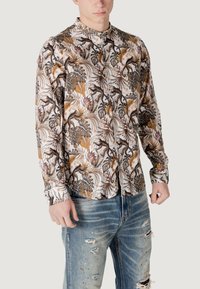 Camicia button-up in tessuto leggero con un motivo di foglie tropicali e scimmie, caratterizzata da colori marrone, crema e arancione. Design fitted.