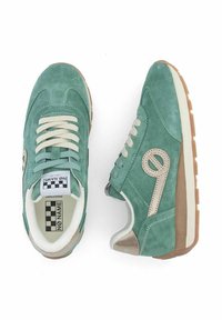 Baskets en daim vert avec des lacets crème, accents beiges et semelles en gomme texturée. Présente un logo circulaire sur le côté et une étiquette à carreaux à l'intérieur.