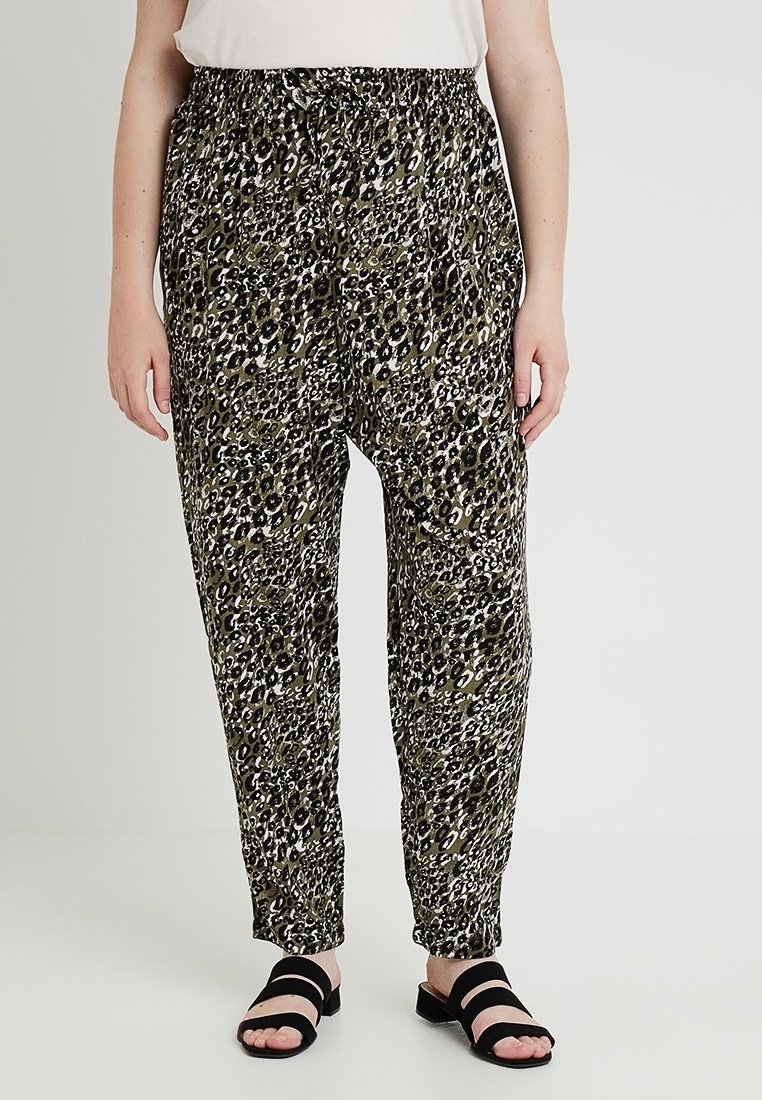 Lossere, lichtgewicht broeken in een dierenprint met tinten groen, zwart en beige. Voorzien van een elastische tailleband en taps toelopende pijpen.