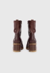 Bottines en cuir marron avec un design froncé, des fermetures éclair latérales et un talon épais empilé au fini texturé.