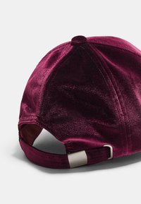 Burgunderfarbenes Samtmütze mit glatter Oberfläche, gebogenem Schirm und verstellbarem Riemen mit metallischer Schnalle auf der Rückseite.