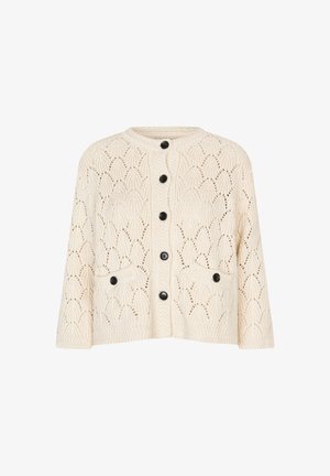Cream-colored knitted cardigan with black buttons down front and on two front pockets, featuring a leaf-like open knit pattern.