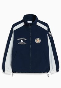 Navy blue windbreaker jacket with white side panels. Features a high collar, full zipper, and embroidered text on the front and sleeves.