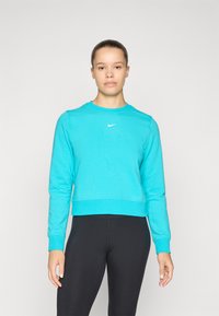 Gekürzter türkisfarbener Sweatshirt aus weichem Stoff, mit langen Ärmeln und einem gerippten Halsausschnitt, sowie einem kleinen weißen Nike-Logo auf der Brust.