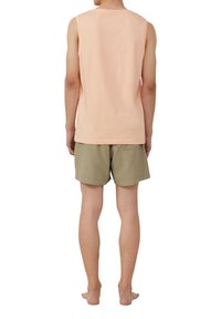 Lichtroze mouwloos shirt gecombineerd met olijfgroene shorts. Het shirt heeft een ronde halslijn en de shorts hebben een achterzak.