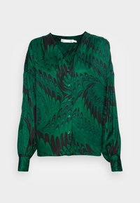 Grön och svart marmorerad mönstrad blus med V-ringning, långa ärmar, knäppning fram och blå knappar på ett slätt tyg.