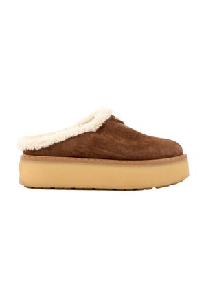 Brun ruskind slip-on sko med tyk beige platformsål og hvid fluffy foring omkring åbningen.