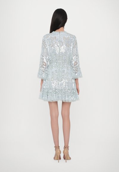Abito di paillettes azzurro chiaro con gonna svasata, maniche a tre quarti e zip sulla schiena. Presenta motivi intricati e tessuto testurizzato.