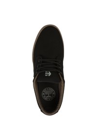 Black canvas shoe with a round toe, lace-up design, brown textured lining, and a circular logo on the insole.