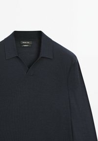 Temně modré vlněné polo tričko s výstřihem do V a krátkými rukávy, které má jemnou texturu a jednoduchý design límečku.