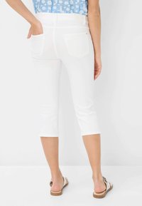 Jean blanc coupé avec une texture lisse et extensible. Doté de deux poches arrière et d'une passante de ceinture, complété par des coutures de couleur claire.