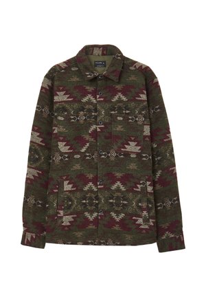 Veste à boutonnière avec col dans des motifs géométriques tribaux verts, bordeaux et beige, dotée de deux poches poitrine et de deux poches avant inférieures.
