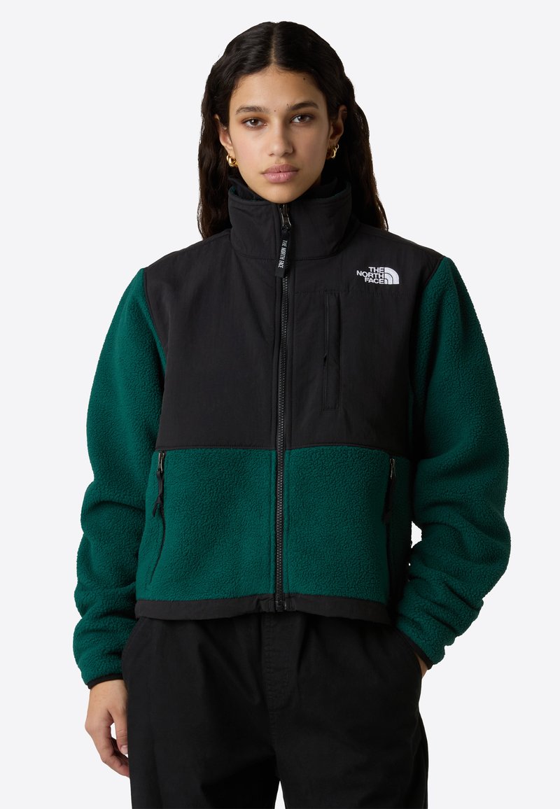 Giacca nera e teal con zip e colletto alto, realizzata in tessuto pile, con tasche con zip e dettaglio logo sul petto.