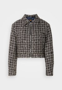 Giacca in tweed nera e bianca, tagliata, con colletto, zipper frontale e motivo testurizzato su tutta la superficie. Foderata con un interno blu navy.