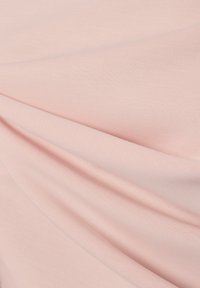 Tessuto rosa chiaro con una superficie liscia e leggermente elastica, caratterizzato da pieghe diagonali che creano una morbida caduta e profondità.