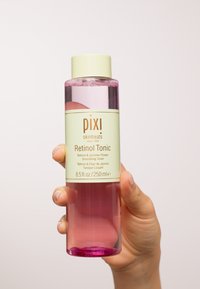 Klar flaske med Pixi Retinol Tonic med en rosa væske, grønn etikett og hvit kork. Inneholder 250 ml, designet for å være et smoothing toner.