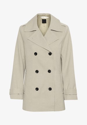 Bēšs dubultais mētelis, izgatavots no teksturēta auduma, ar plašu apkakli, melnām pogām un sānu kabatām.