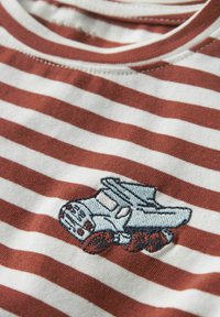 Bavlněné tričko s horizontálními červenými a bílými pruhy, kulatým výstřihem a modrou vyšitou grafikou náklaďáku na přední straně.